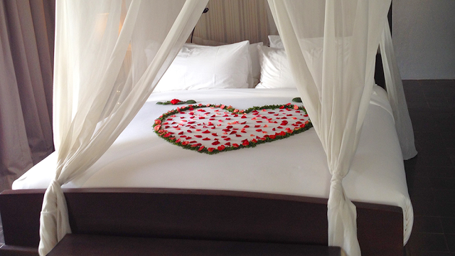 a bed with a heart made of rose petals
