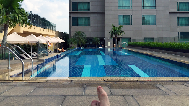 a person's foot in front of a swimming pool