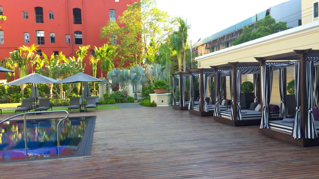 a pool with lounge chairs and a building in the background