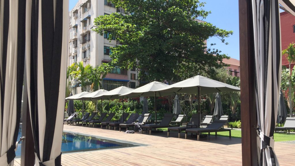 a pool with umbrellas and lounge chairs