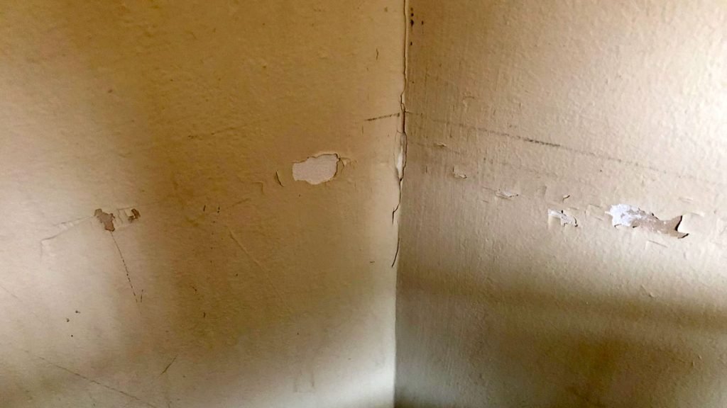 a corner of a room with a crack in the wall