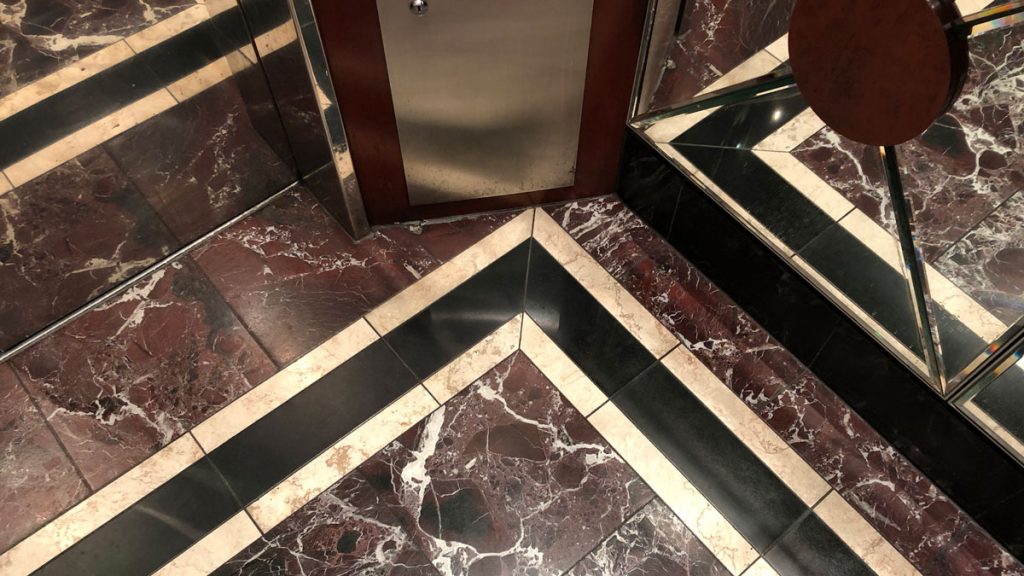 a marble floor with a door and mirror