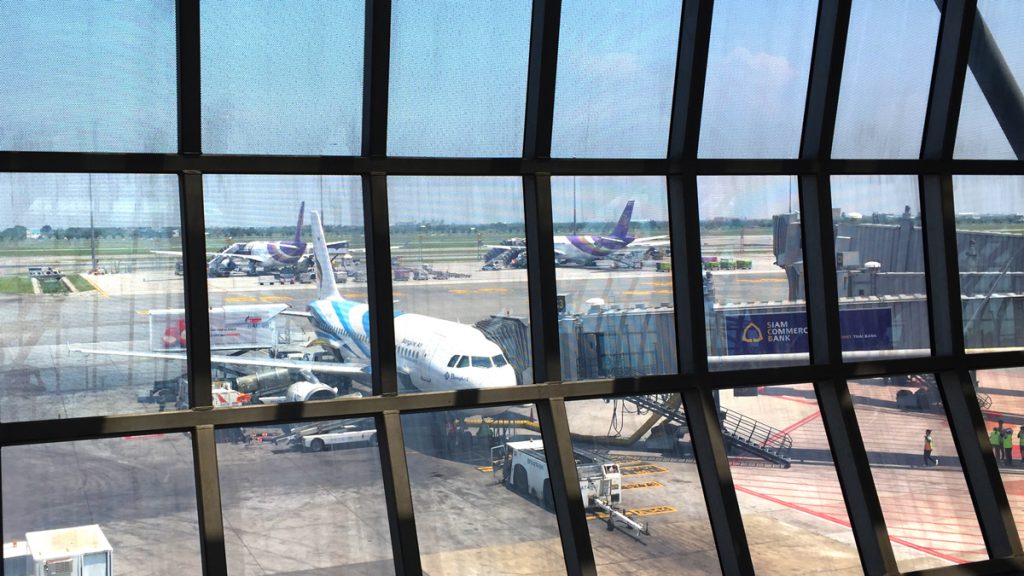 a window with a view of airplanes on the runway