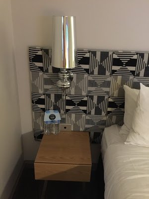 a lamp on a table next to a bed