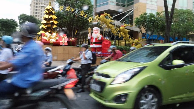a group of people on a street with a christmas decoration
