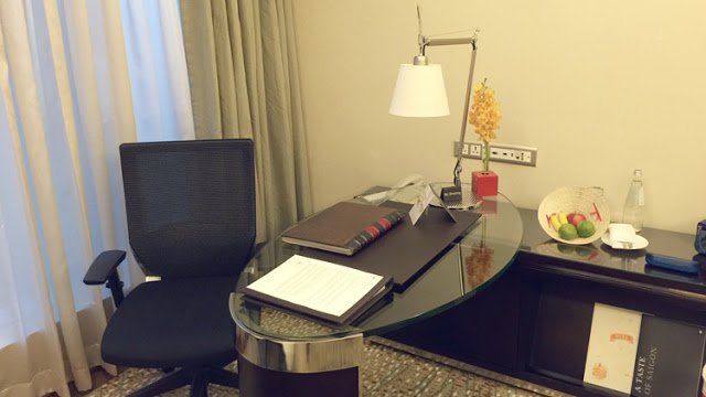 a desk with a lamp and a book on it