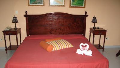 a bed with a heart shaped towel on it