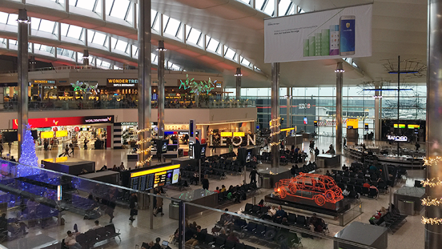 a large airport terminal with people waiting for their flight