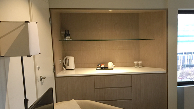 a shelf with glass shelves and a coffee pot
