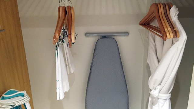 a ironing board and swingers in a closet