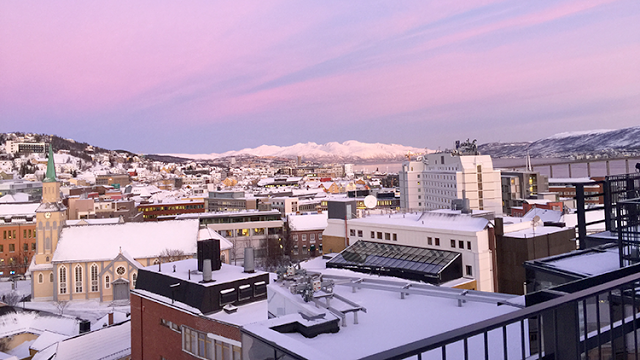 a rooftop view of a city with snow on the roof