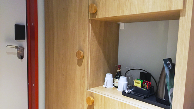 a wooden cabinet with a shelf and objects on it