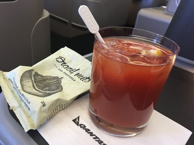 a glass of liquid with a spoon next to a bag of food