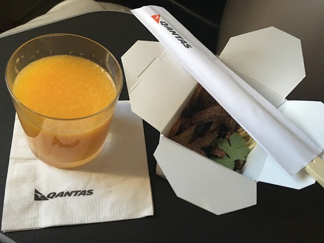 a take out box with a drink and a glass of orange juice