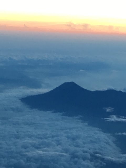 a mountain with clouds and sun