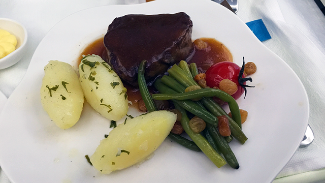 a plate of food with a tomato and beans