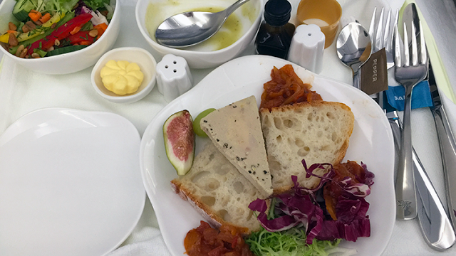 a plate of food with a spoon and a bowl of soup