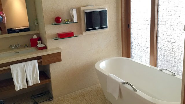 a bathroom with a bathtub and a television