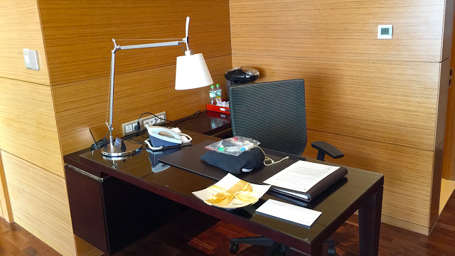 a desk with a lamp and a bag on it