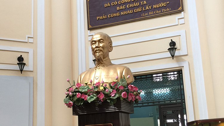 a statue of a man with flowers on a podium