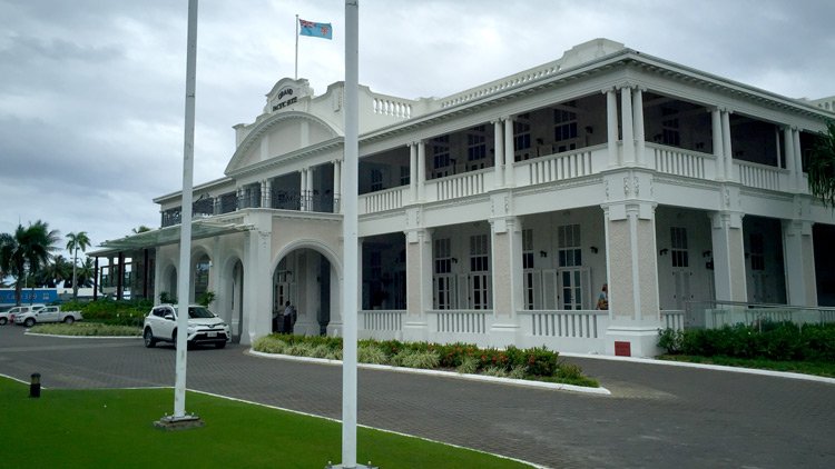 a white building with columns and a flag