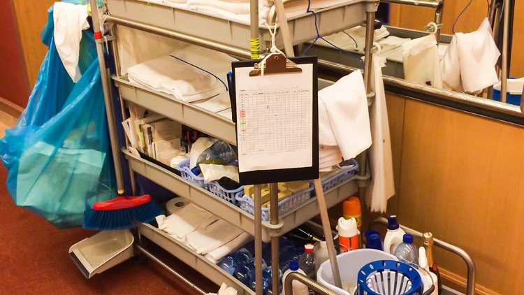 a cleaning cart with a clipboard and cleaning supplies