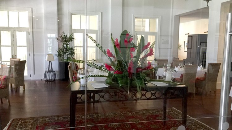 a table with flowers and a red rug in a room
