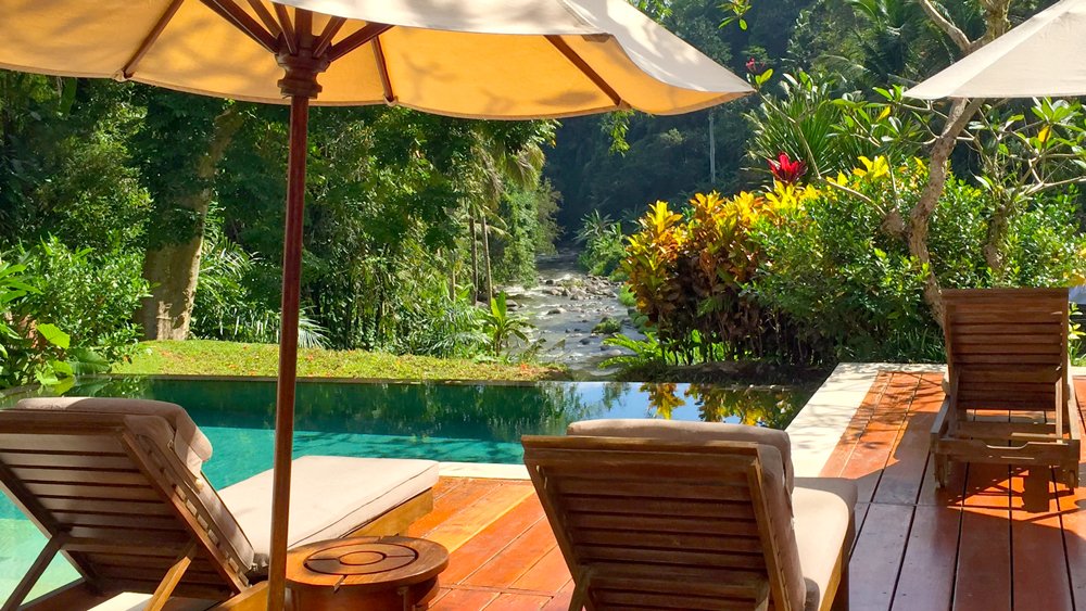 a pool with a deck chair and umbrella