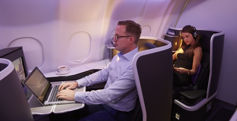 a man sitting in a chair with a laptop on his lap