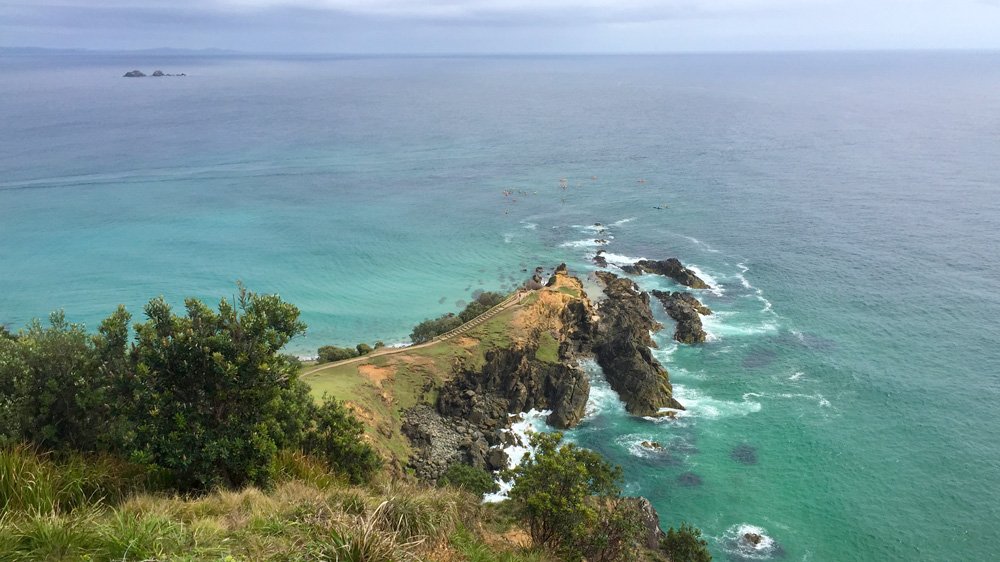 a cliff with a path and a body of water