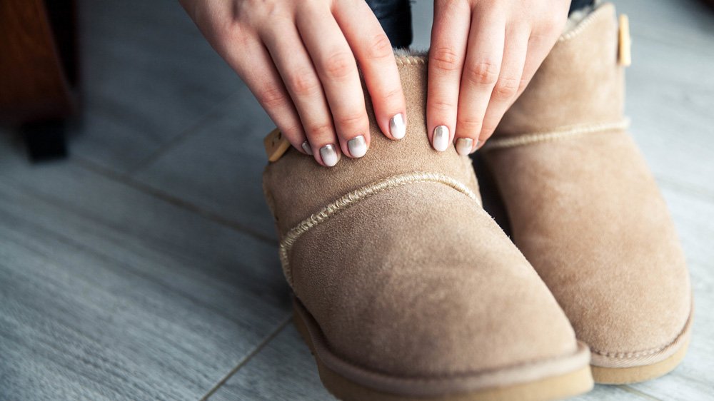 a person's hands on a brown boot