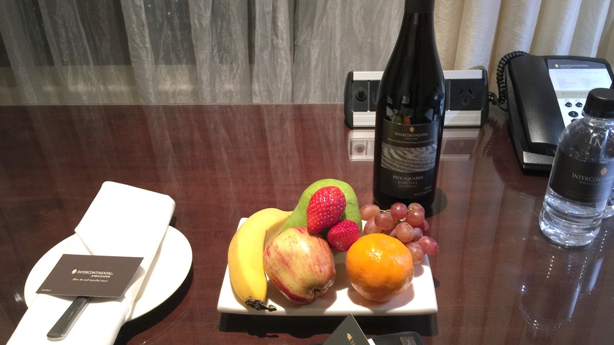 a plate of fruit and a bottle of wine