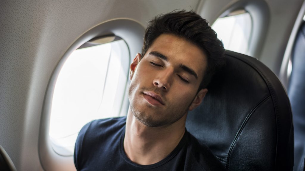 a man sleeping on an airplane