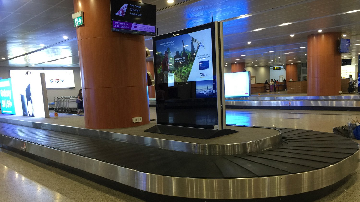 a baggage claim area with a screen on the side