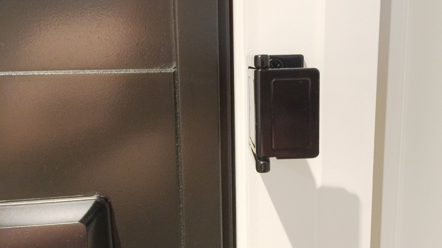 a black hinge on a white door