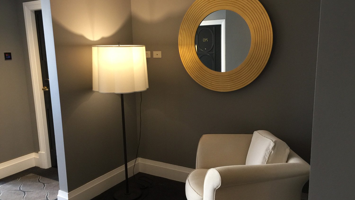 a white chair and a lamp in a room