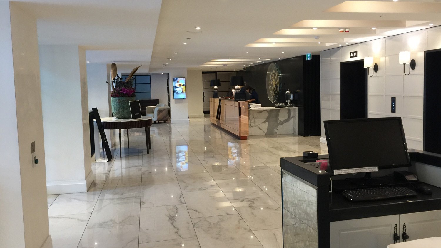 a lobby with a marble floor and a desk and a computer