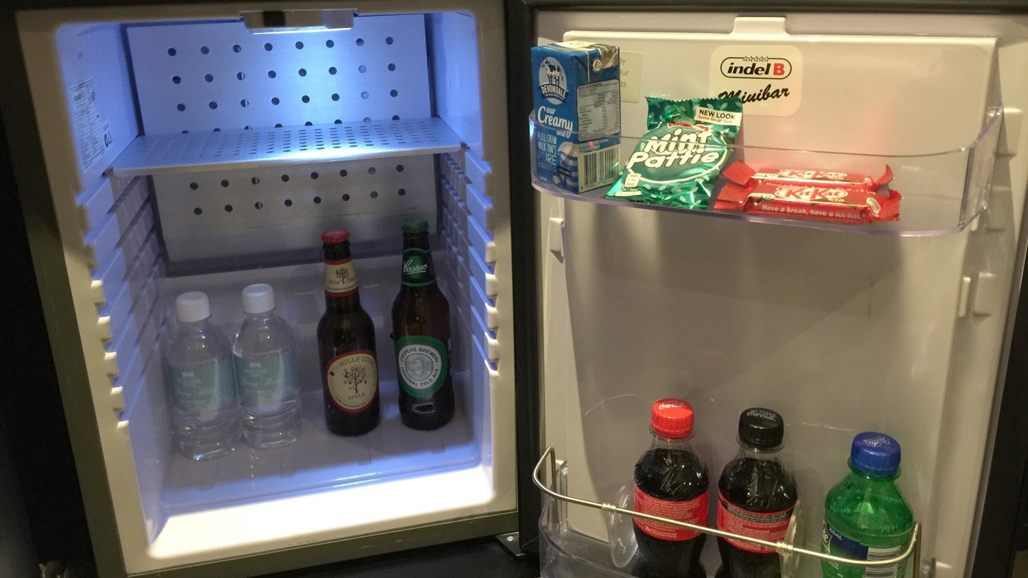 a mini fridge with drinks and milk