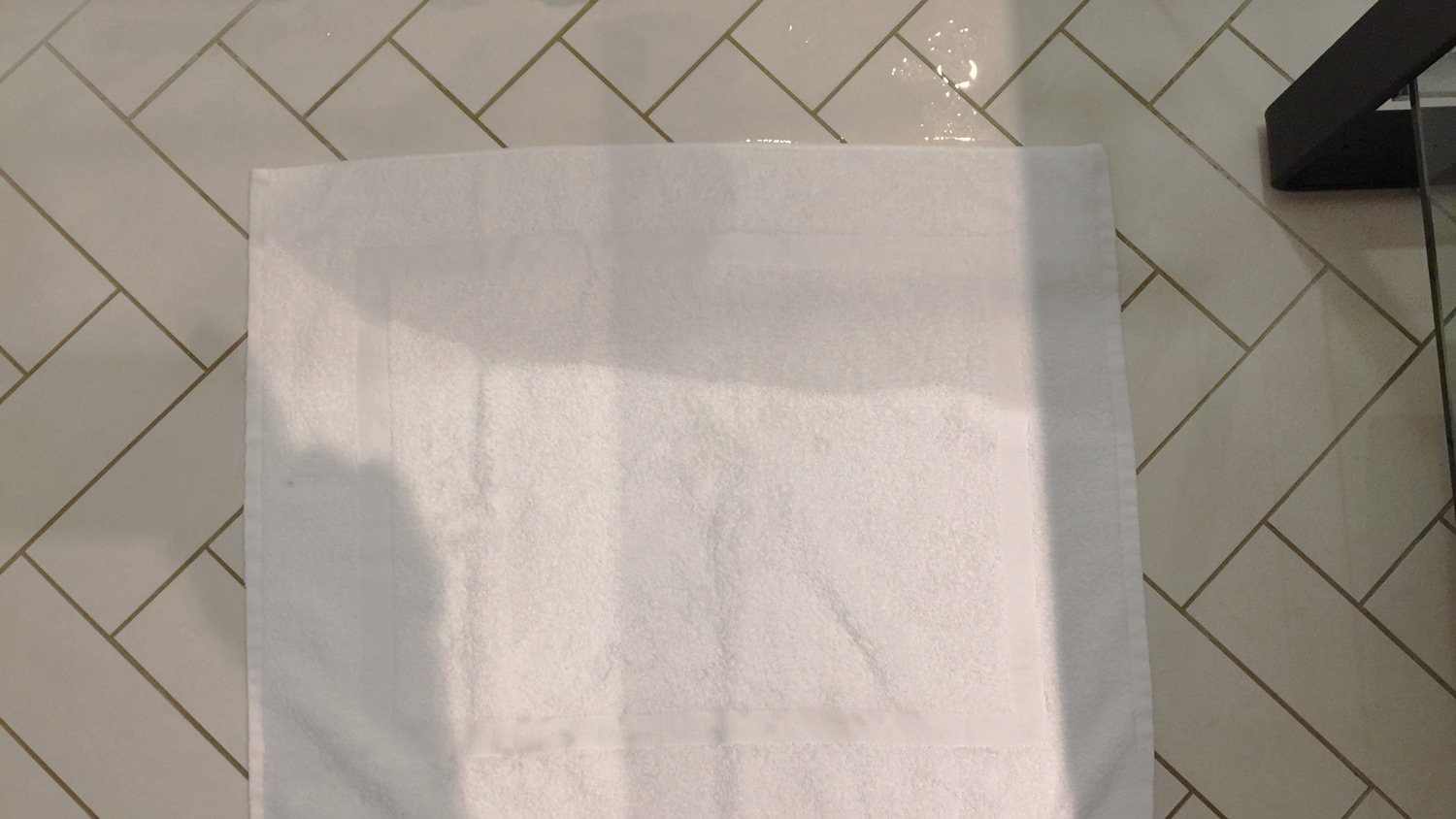 a white towel on a tile floor