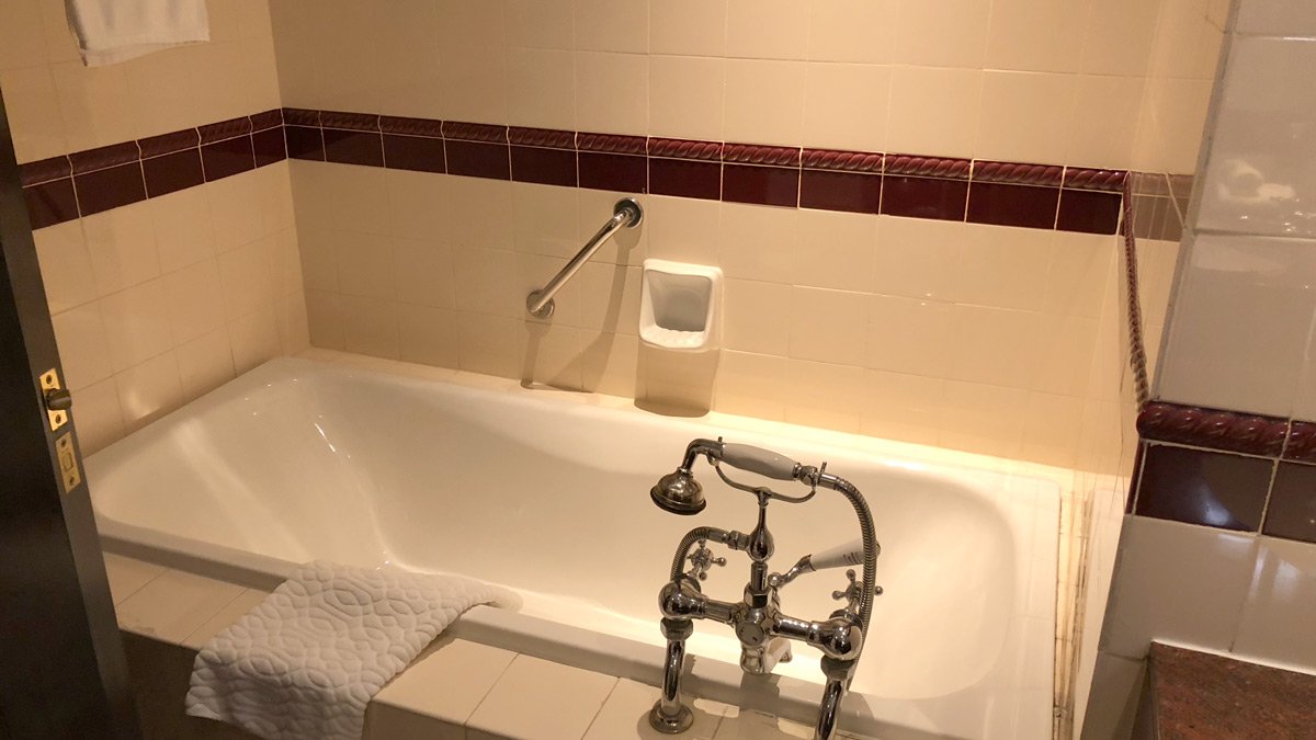 a bathtub with a faucet and a towel
