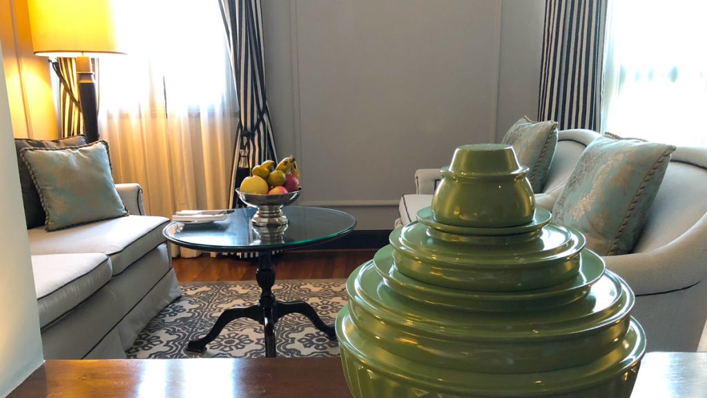 a green vase on a table in a living room
