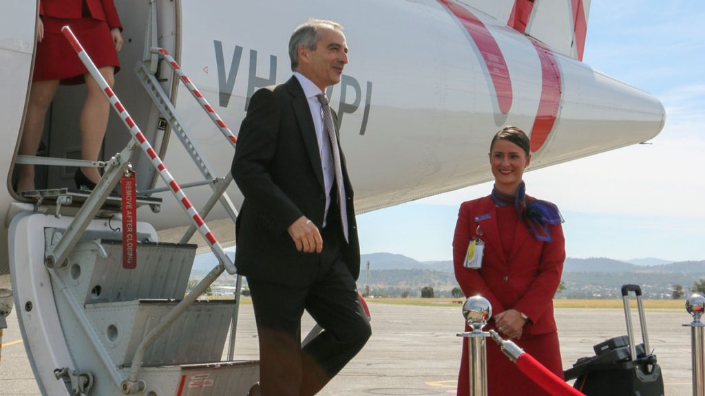a man and woman standing next to a plane