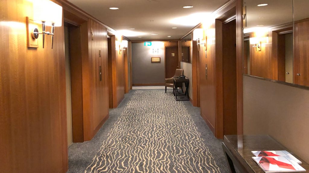 a hallway with wood doors and a striped carpet