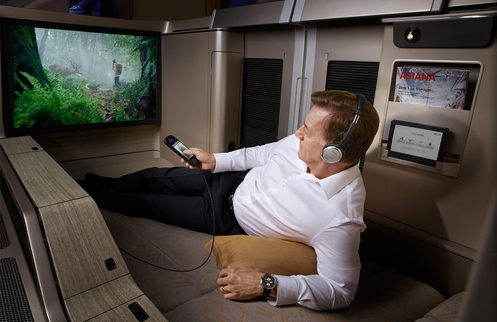 a man sitting on a couch with headphones and a remote control