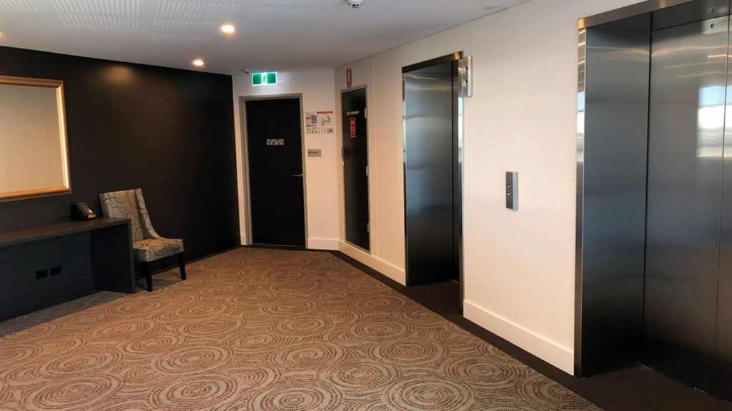 a room with a chair and elevator doors