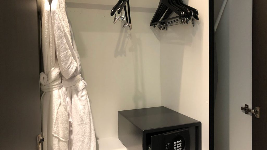 a black safe with a combination lock and swingers in a white room