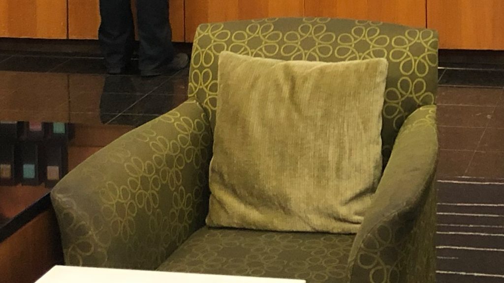 a green chair with a pillow
