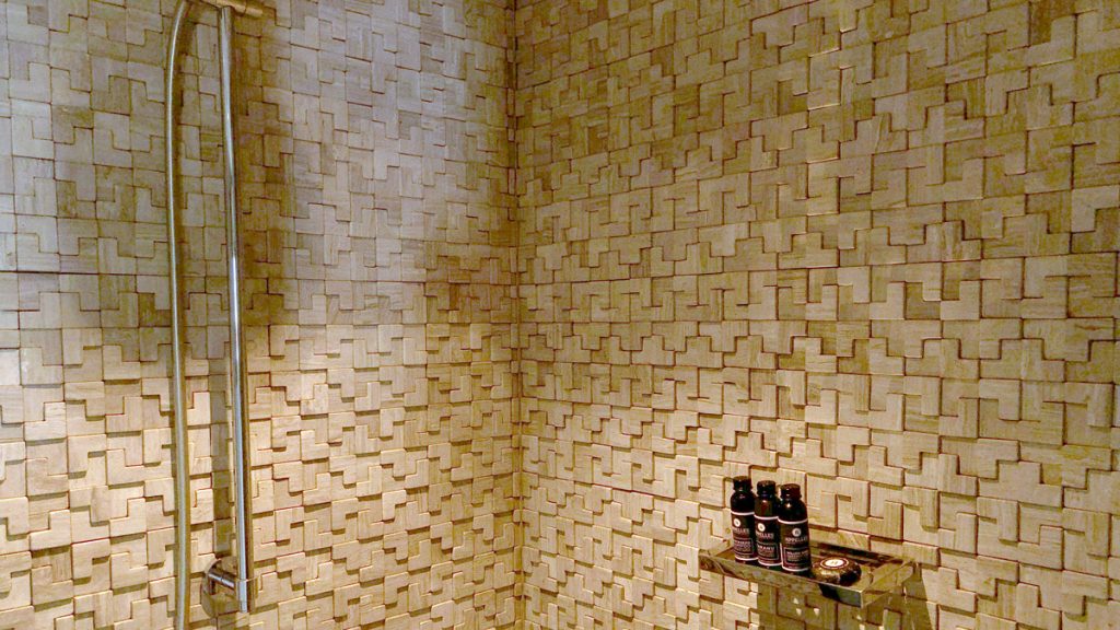 a bathroom with a tile wall