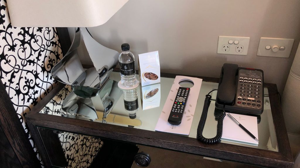 a phone and a bottle of water on a glass table