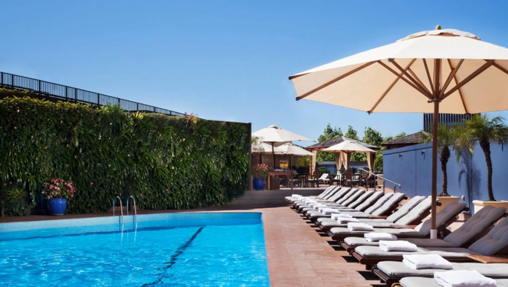 a pool with lounge chairs and umbrellas